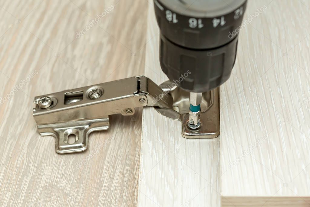 Tür wird eingestellt und Scharnier justiert